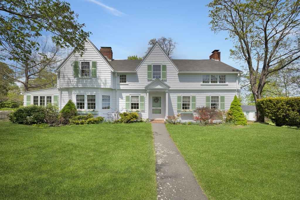 a front view of a residential houses with yard and green space