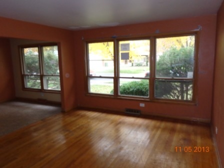 14437 Sanderson Avenue Dolton, IL 60419 - Photo 2 of 8 an empty room with wooden floor and windows