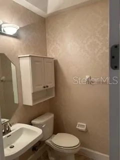 a bathroom with a toilet a sink and mirror