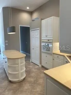 a kitchen with a refrigerator and white cabinets