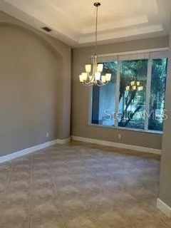 a view of a chandelier in big room with wooden floor