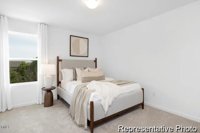 a large bed sitting in a bedroom next to a window