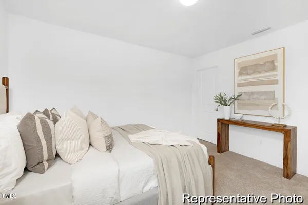a bedroom with a bed and a potted plant