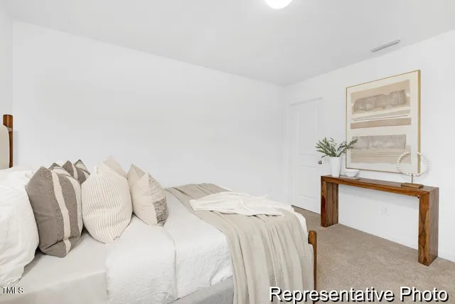 a bedroom with a bed and a potted plant