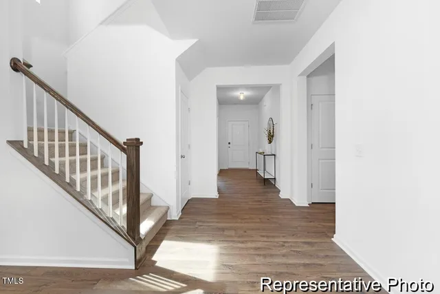 a view of a hallway with wooden floor and staircase
