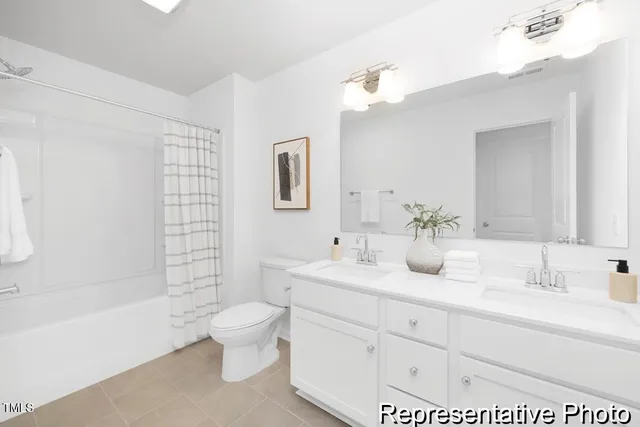 a bathroom with a double vanity sink toilet mirror and bathtub