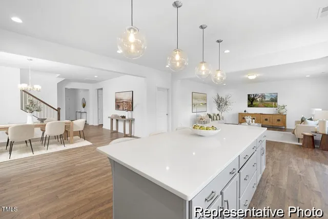 a large kitchen with kitchen island a island a stove a table and chairs