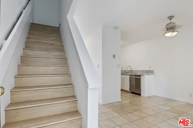 an empty room with wooden floor and mirror