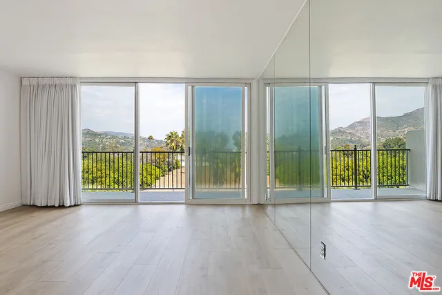 an empty room with sliding door and wooden floor