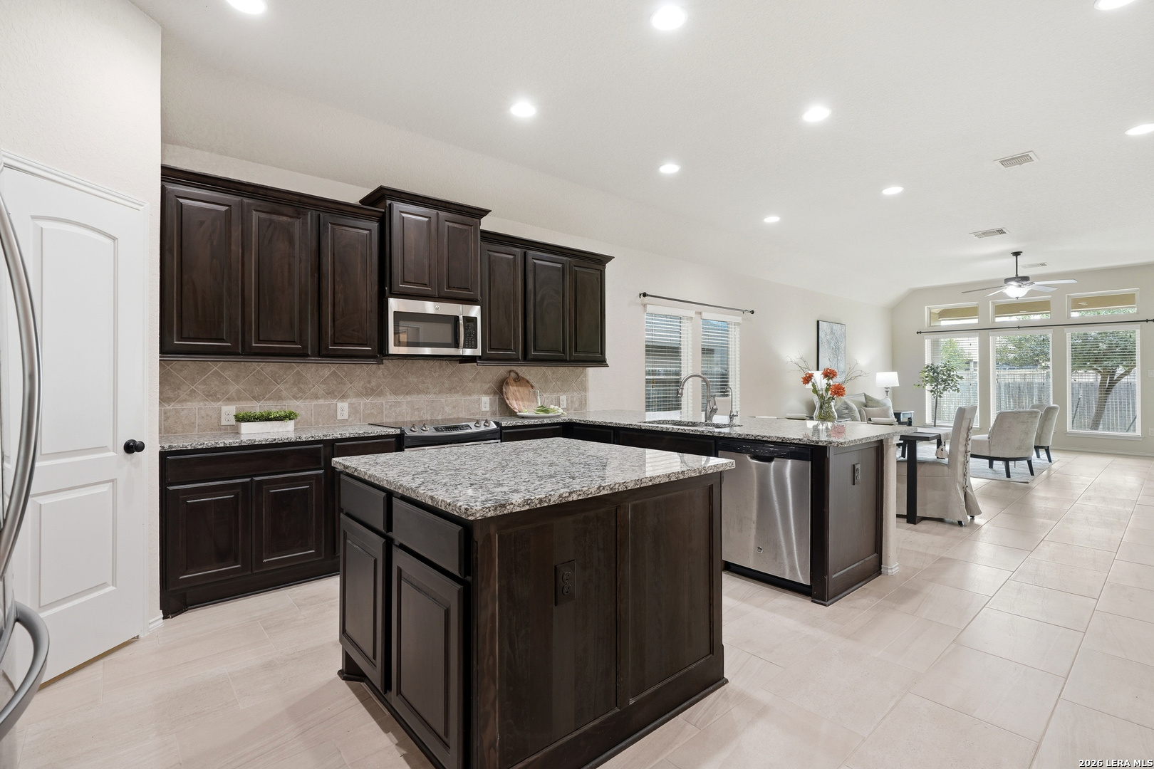 2129 Range Road Seguin, TX 78155 - Photo 9 of 41 a kitchen with stainless steel appliances granite countertop a stove top oven a sink dishwasher and a refrigerator with wooden cabinets