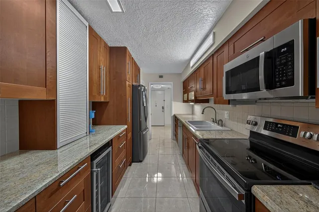 a kitchen with stainless steel appliances granite countertop a stove a sink and a microwave