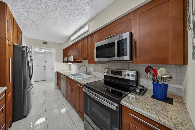 a kitchen with stainless steel appliances granite countertop a stove and a refrigerator