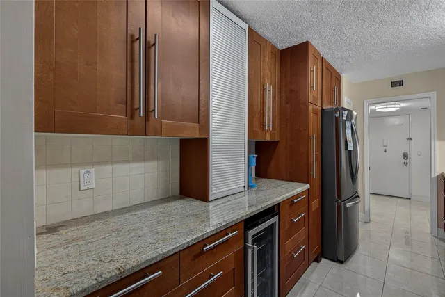 a kitchen with stainless steel appliances granite countertop a refrigerator and a sink