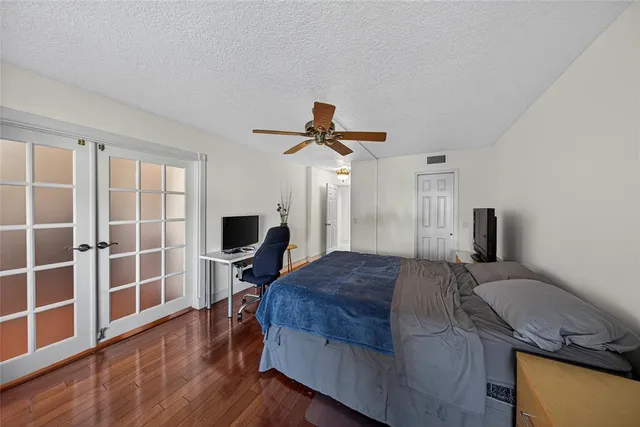 a bedroom with a bed and wooden floor