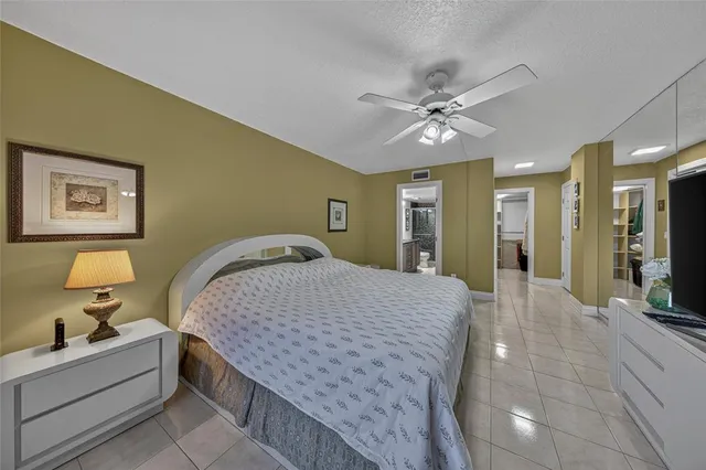 a spacious bedroom with a bed and a chandelier