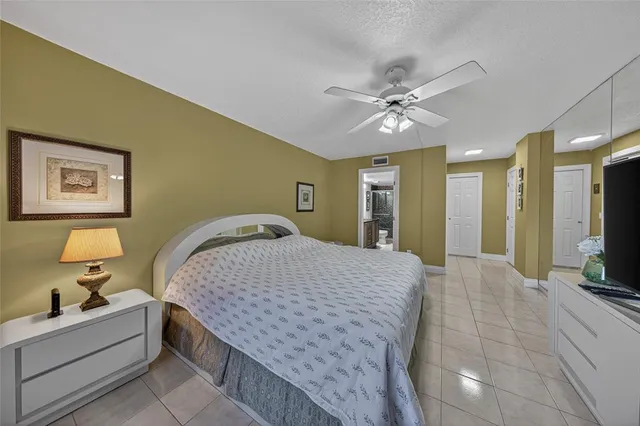 a spacious bedroom with a bed and a flat screen tv