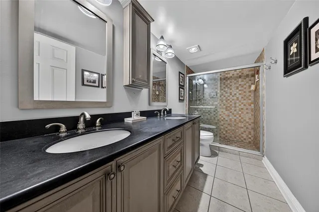 a bathroom with a granite countertop sink a mirror a vanity and a shower