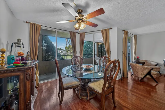 a dining room with furniture a chandelier and wooden floor