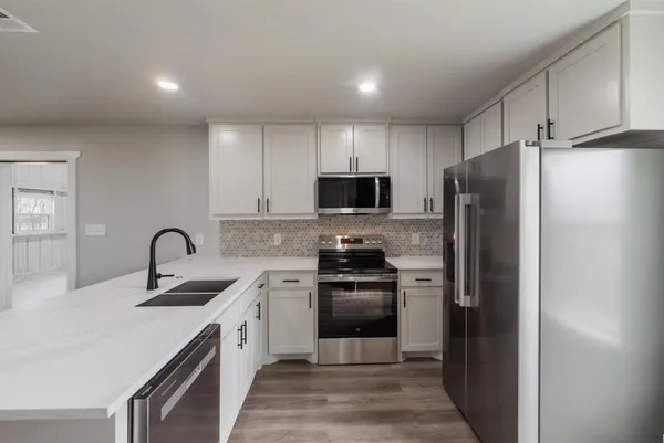 a kitchen with a sink stainless steel appliances and cabinets