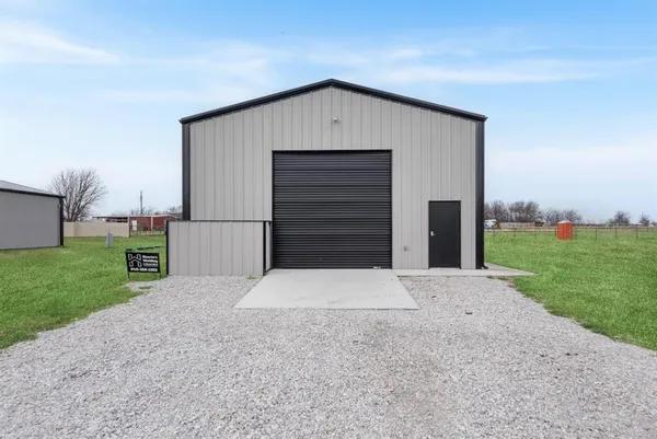 a view of a wooden house with a big yard and large trees