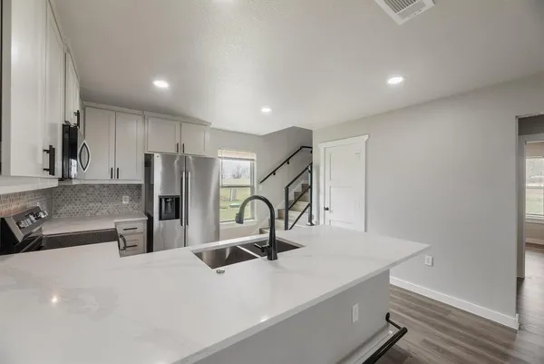 a kitchen with stainless steel appliances a sink stove and refrigerator