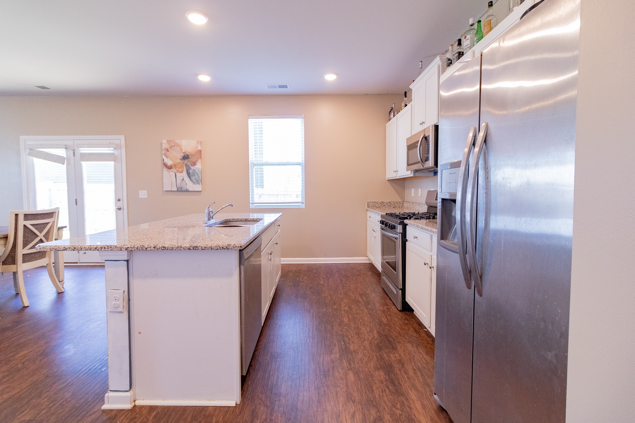 753 Prominence Road Columbia, TN 38401 - Photo 19 of 37 a kitchen with kitchen island granite countertop wooden floors and stainless steel appliances