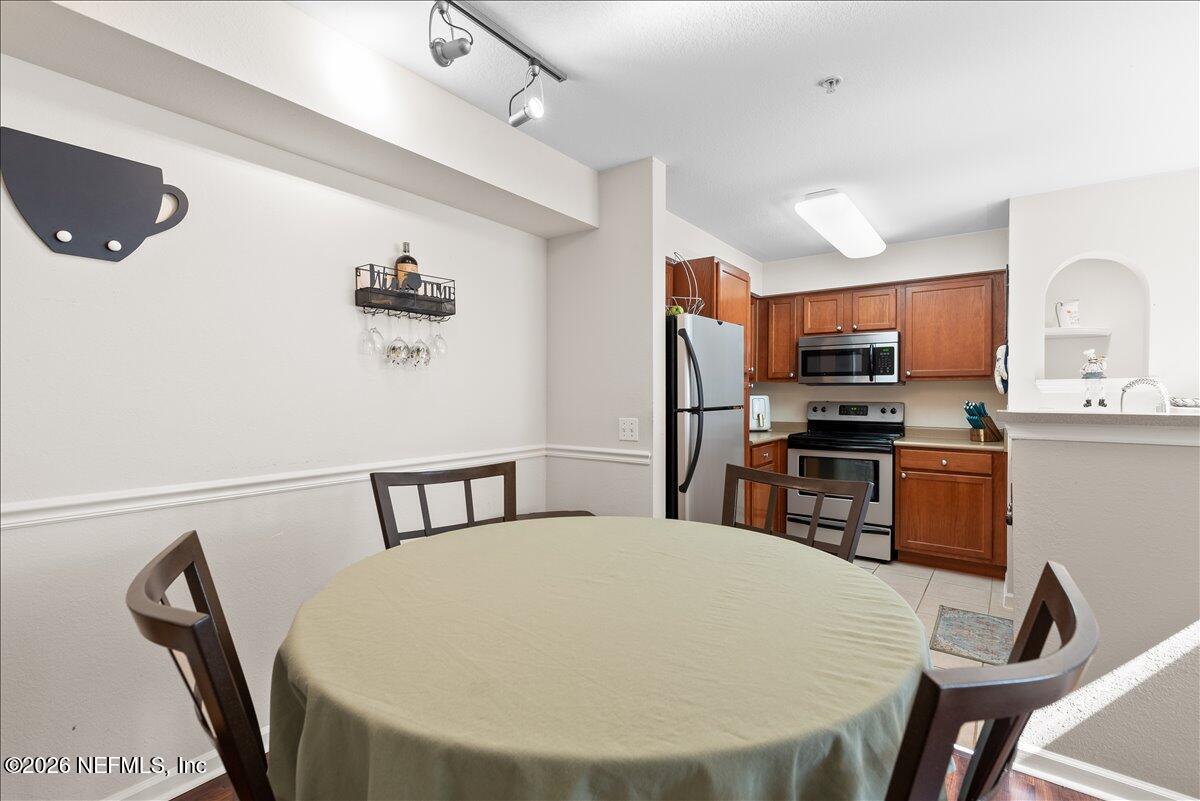 8550 Touchton Road, Unit 1437 Jacksonville, FL 32216 - Photo 13 of 36 a kitchen with stainless steel appliances a dining table chairs and refrigerator