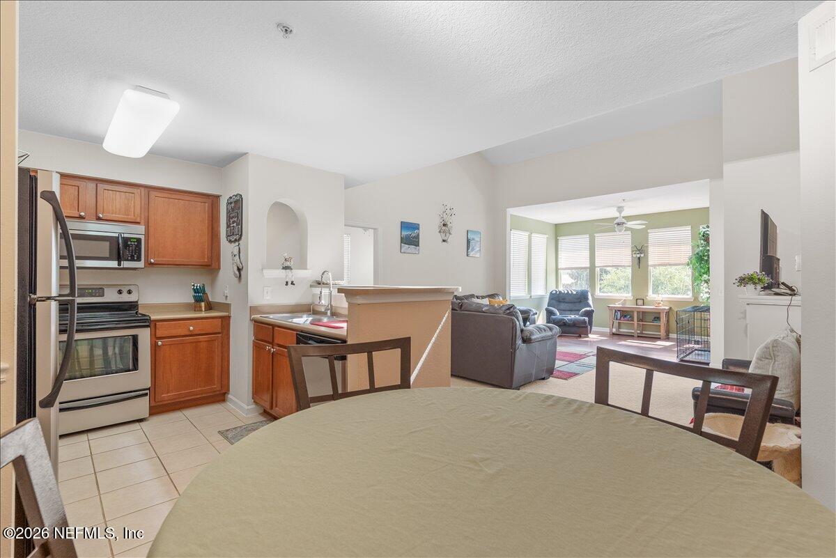 8550 Touchton Road, Unit 1437 Jacksonville, FL 32216 - Photo 14 of 36 a large kitchen with a stove a sink dishwasher a dining table and chairs with wooden floor