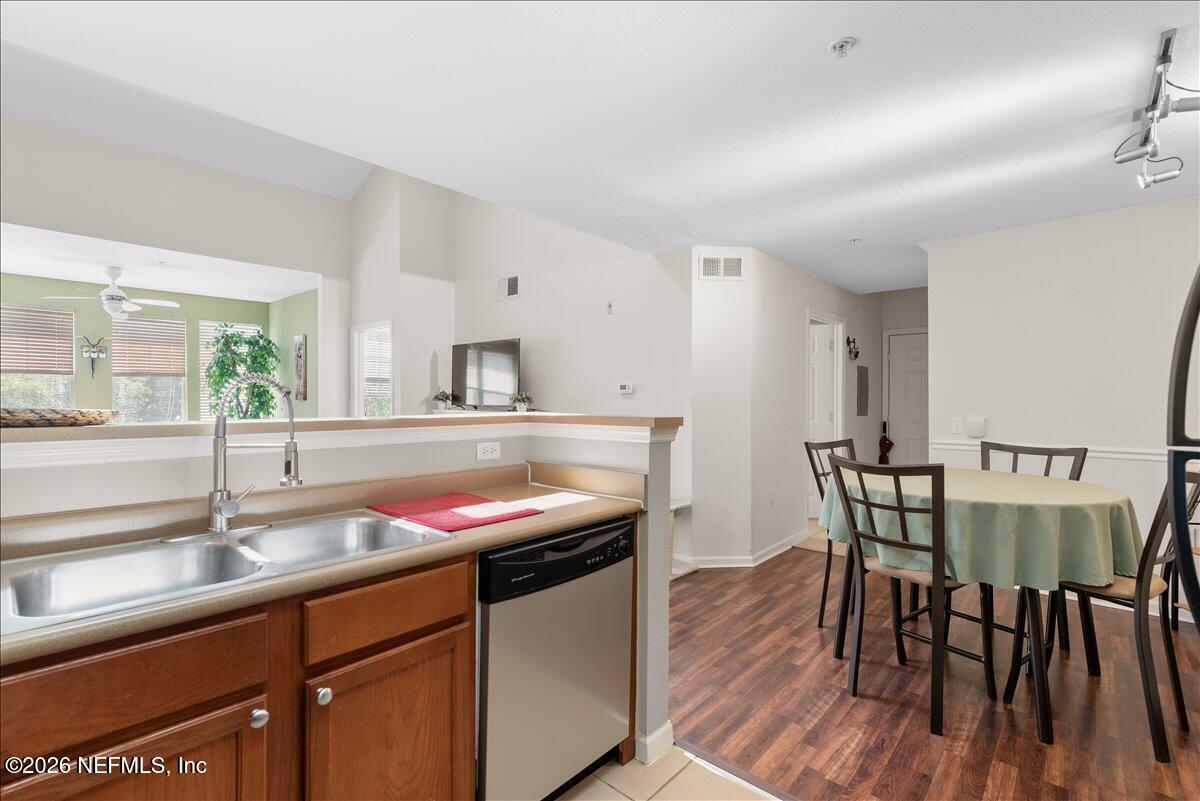 8550 Touchton Road, Unit 1437 Jacksonville, FL 32216 - Photo 16 of 36 a kitchen with stainless steel appliances granite countertop a kitchen island hardwood floor sink dining table and chairs