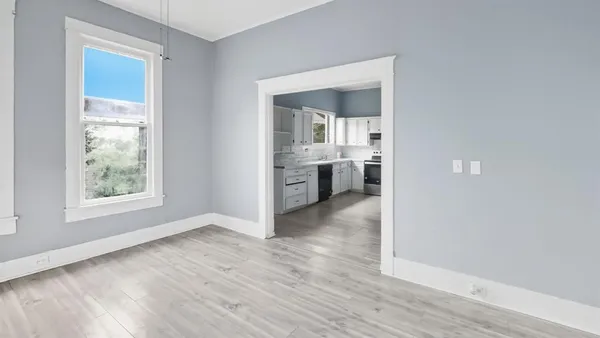 an empty room with wooden floor and a window