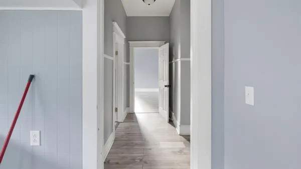 a view of a hallway with wooden floor