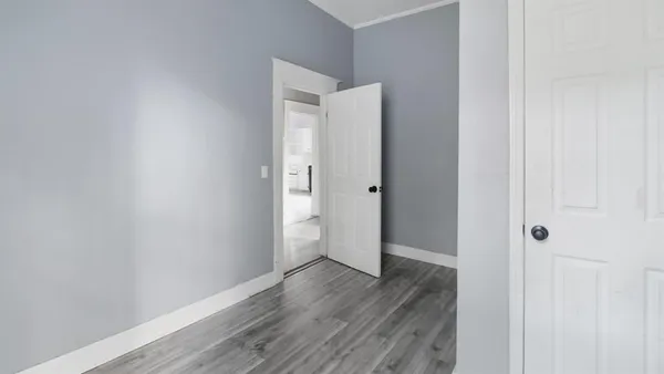 a view of an empty room with wooden floor