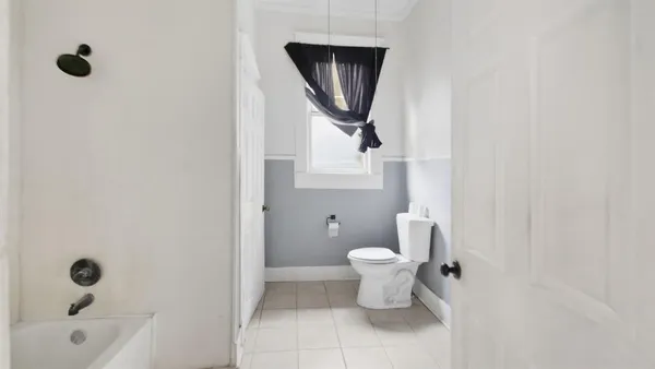 a bathroom with a toilet a sink a mirror and bathtub