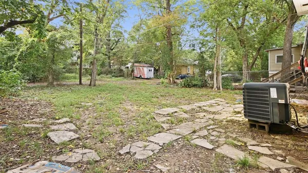 a backyard of a house with barbeque oven and trees