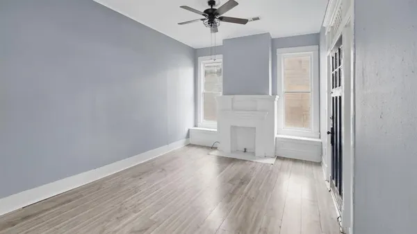 an empty room with wooden floor and windows