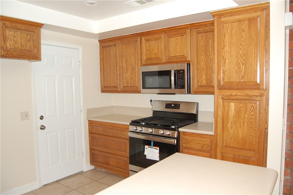 8484 Monteel Place Riverside, CA 92504 - Photo 10 of 34 a kitchen with a stove and a microwave