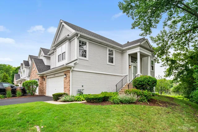 a front view of a house with a garden and plants