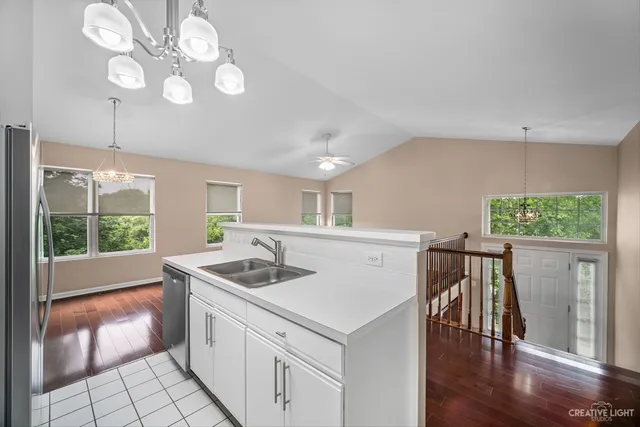 a kitchen that has a sink a stove a microwave oven with a dining table and chairs