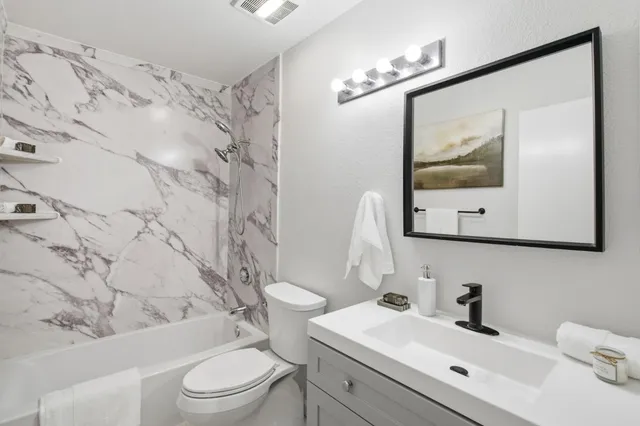 a bathroom with a toilet sink and mirror