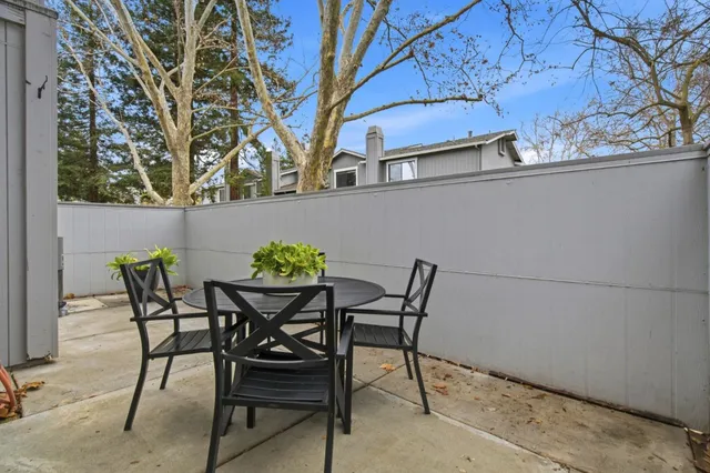 a view of a chairs and table in the back yard