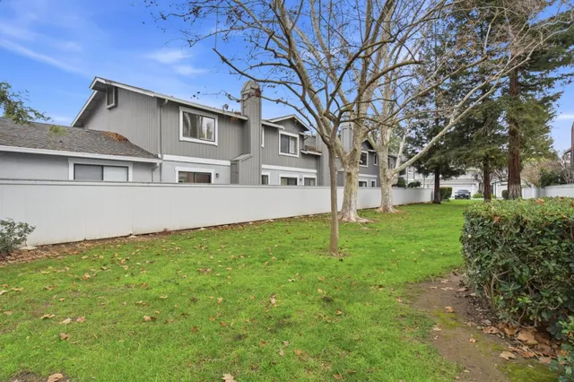 a white house that has tree in front of it