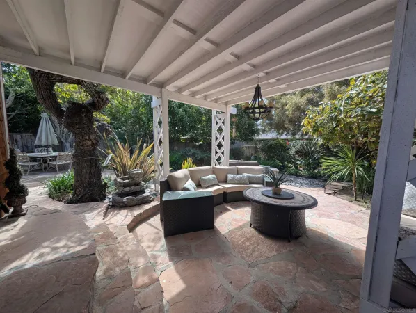 a living room with patio furniture and a potted plant