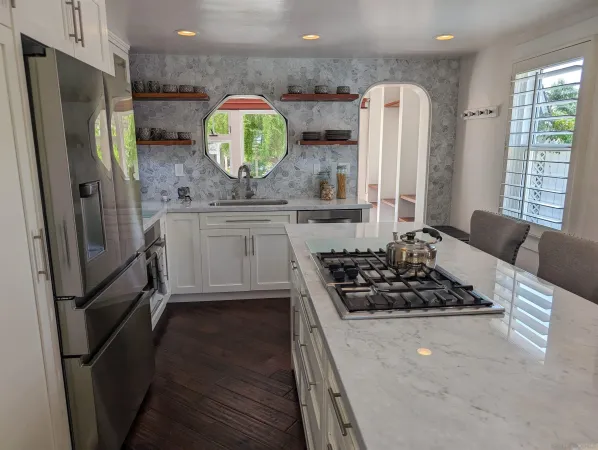 a kitchen with stainless steel appliances a stove a refrigerator and a wooden floor