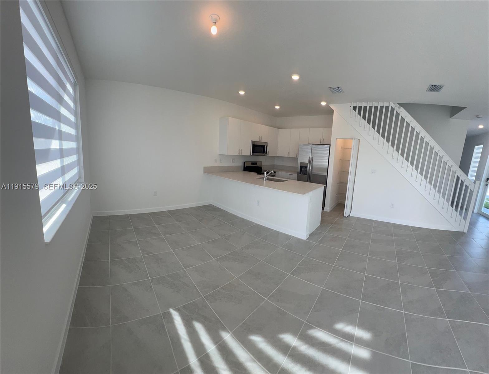 1455 Southeast 6th Terrace Homestead, FL 33034 - Photo 5 of 16 a living room with stainless steel appliances a couch and a window