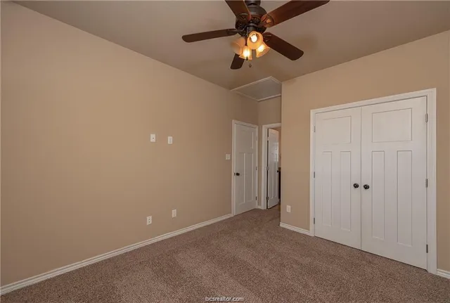 an empty room with a ceiling fan and a chandelier fan
