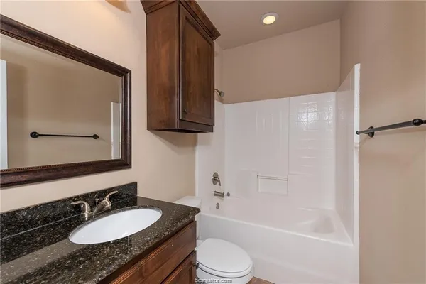 a bathroom with a granite countertop sink toilet and shower