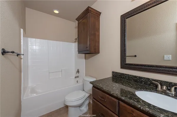 a bathroom with a granite countertop sink toilet and shower