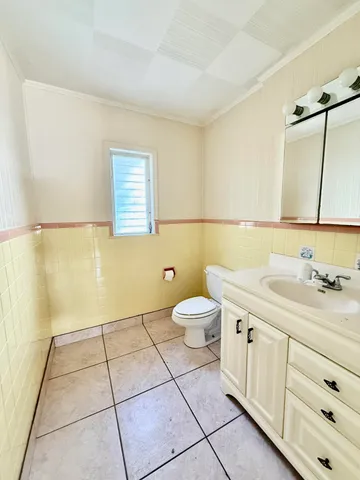 a bathroom with a granite countertop sink a toilet and a mirror