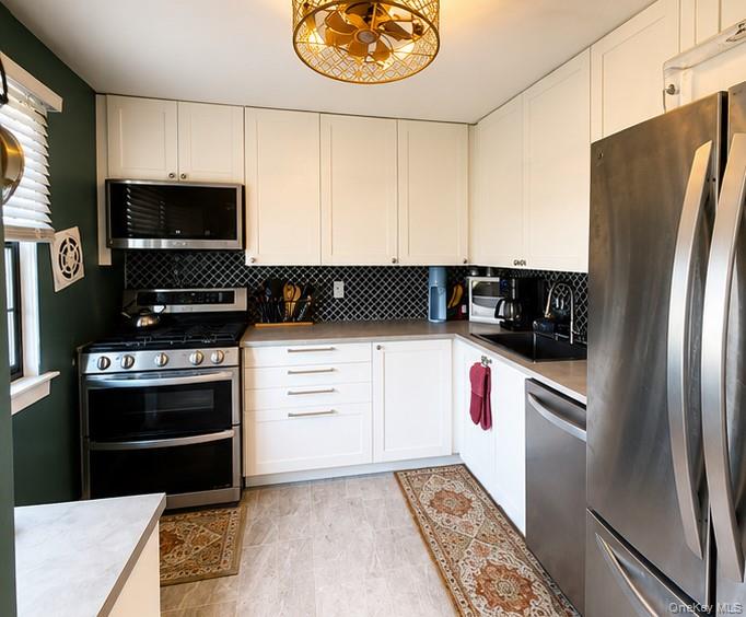 335 Mariners Way Copiague, NY 11726 - Photo 3 of 12 a kitchen with a refrigerator stove and microwave