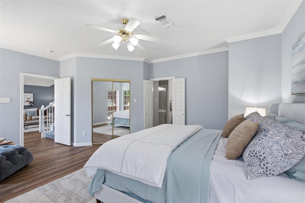 14584 Blueberry Court Addison, TX 75001 - Photo 22 of 40 a bedroom with a large bed and a chandelier